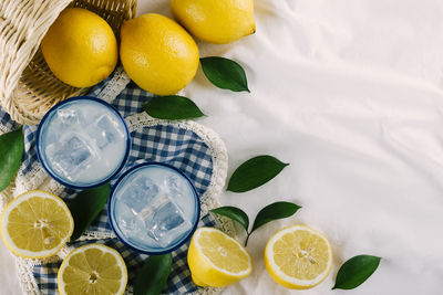 Top view of lemon juice glasses on a white tablecloth at a picnic