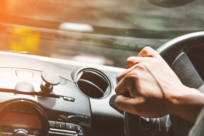 Cropped hand of man driving car