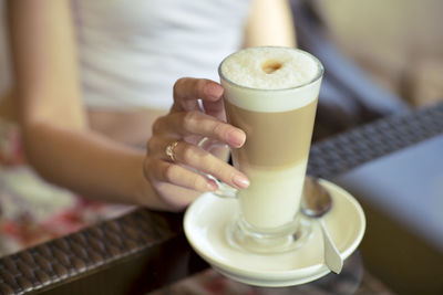 Close-up of hand with coffee at table