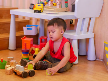 Boy playing with toy on table at home