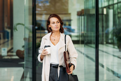 Portrait of young woman standing in city