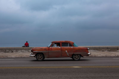 Man driving car on road at seaside