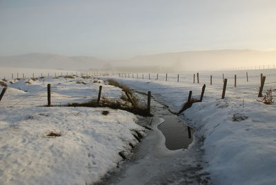 Scenic view of frozen lake against sky during winter