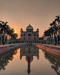 Reflection of building and palm trees in water