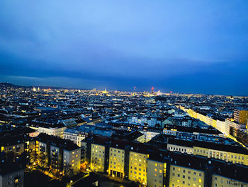 High angle view of illuminated buildings against sky at dusk