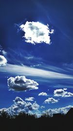 Scenic view of silhouette trees against blue sky