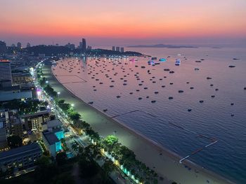 High angle view of buildings by sea against sky during sunset