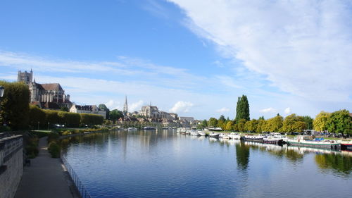 Buildings by river against sky in city