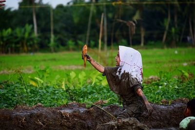 An elementary school girl is catching fish in a play activity while learning outside the classroom.