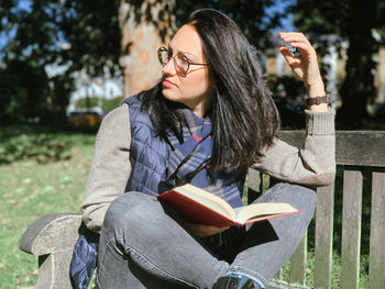 Young woman sitting on book