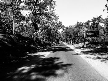 Road amidst trees against clear sky