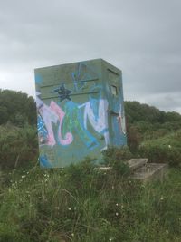 Graffiti on field against sky