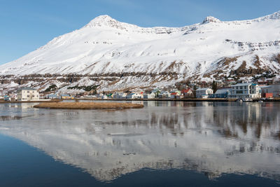 Scenic view of lake by snowcapped mountains against sky