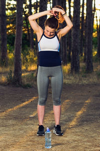 Rear view of woman standing against trees