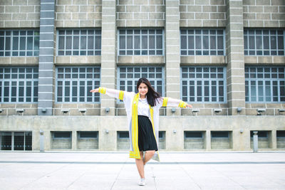 Full length of a woman standing against building