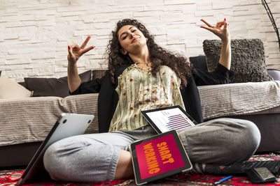 Friends using digital tablet while sitting on sofa at home