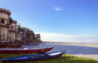 Boats moored on sea against blue sky