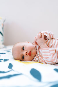 Closeup portrait of a newborn baby girl laying on a colorful blanket