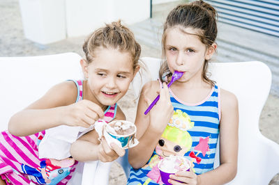 Cute siblings eating ice cream at home
