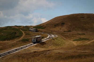 Scenic view of trams amidst field against sky