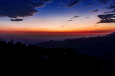 Scenic view of silhouette mountains against sky at sunset