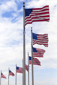 Low angle view of american flags against sky