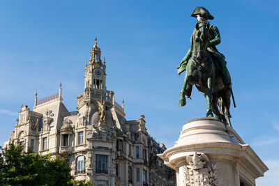 Low angle view of statue of historic building against sky