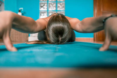 Woman exercising while sitting on mat at home