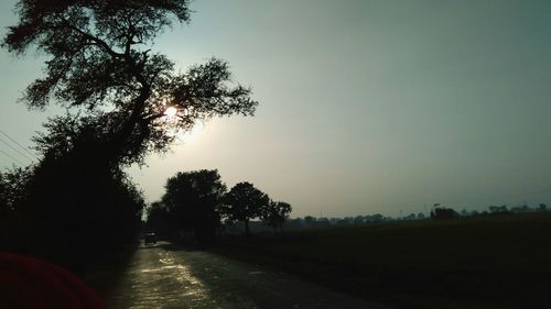 Road amidst trees against clear sky