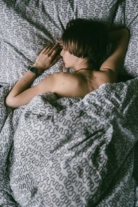 High angle view of woman lying on bed at home