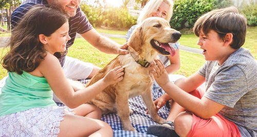 Happy family playing with dog in park