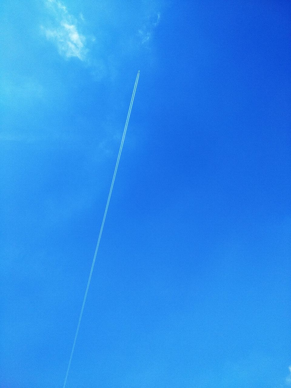 LOW ANGLE VIEW OF VAPOR TRAILS IN BLUE SKY