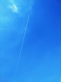 Low angle view of vapor trail against blue sky