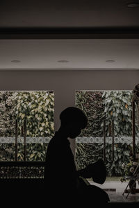 Side view of silhouette man looking at window