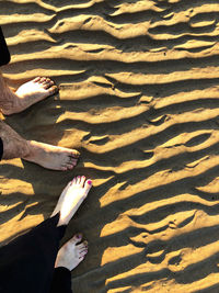 Low section of woman on sand at beach