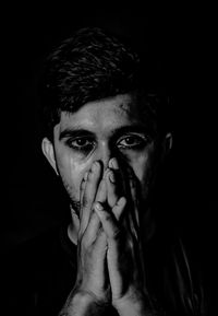 Portrait of young man against black background