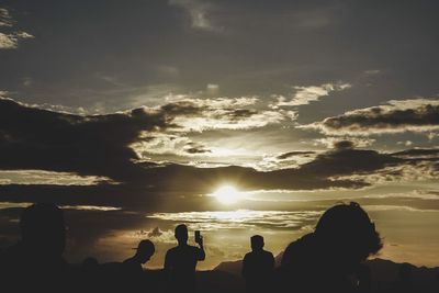 Silhouette people against sky during sunset