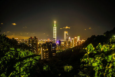 Illuminated buildings against sky at night