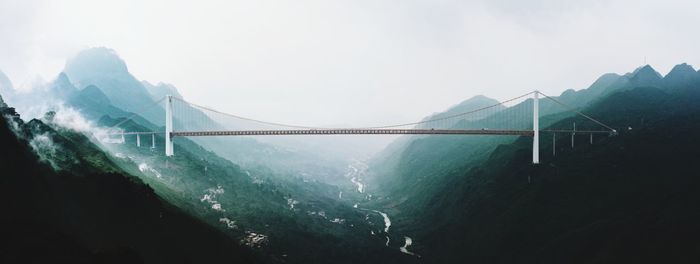 Suspension bridge over bay against sky