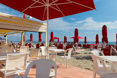 Chairs and tables at restaurant against sky