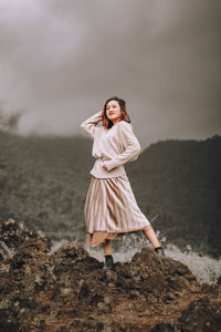 Full length of woman standing on land against sky