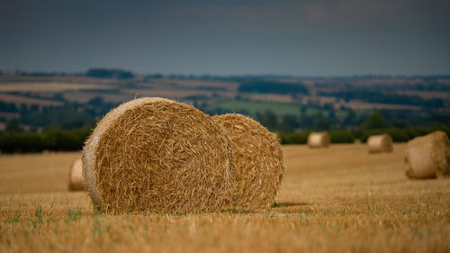 Hay bales on field against sky