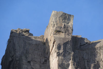 Low angle view of rock formation against clear blue sky