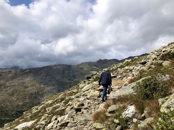 Rear view of men on mountain against sky