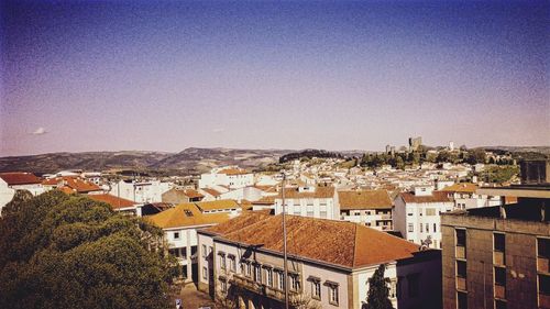 High angle view of houses in town against clear blue sky