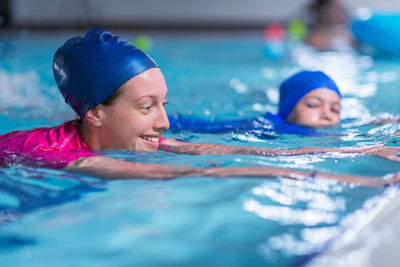 Mother and son swimming in pool