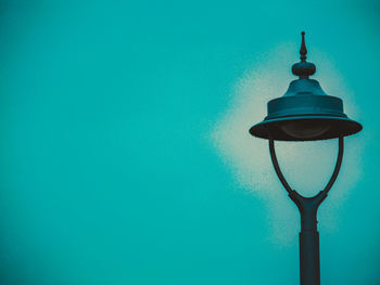 Illuminated light bulb against blue sky