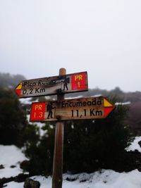 Information sign on snow against clear sky