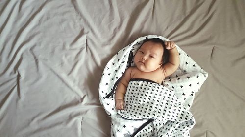 High angle portrait of baby girl sleeping on bed at home