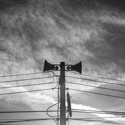 Low angle view of silhouette electricity pylon against sky